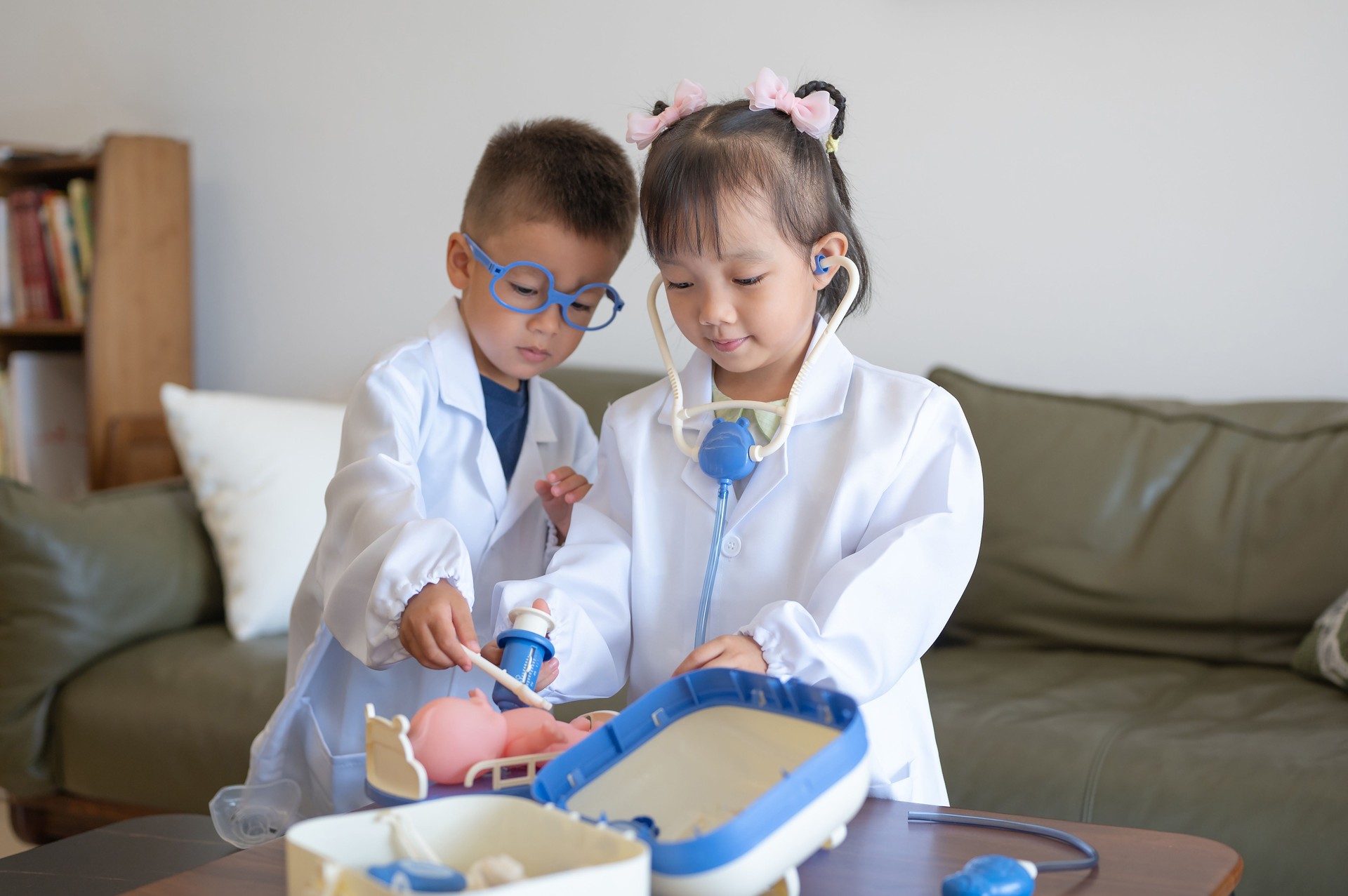 Two children play doctor with toy medical equipment